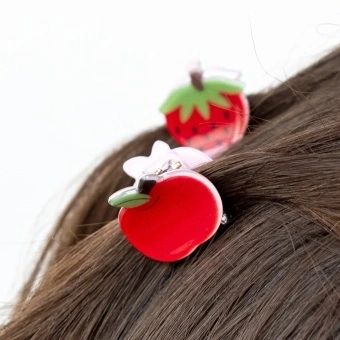 Set of two mini fruit-shaped hair claw clips in strawberry and apple designs.