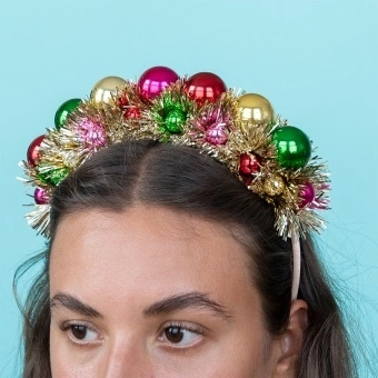 Festive tinsel party headband decorated with colourful jingle bells .