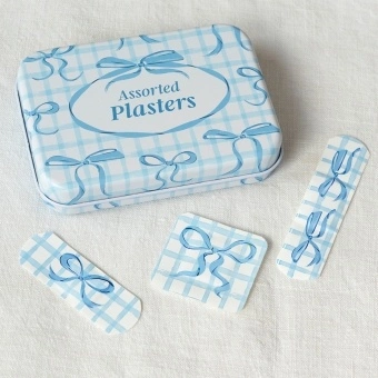 Blue bows-themed plasters in a tin, shown with assorted designs.