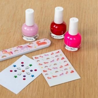 Unicorn nail kit contents including three nail polishes, a unicorn nail file, and unicorn-themed nail stickers.