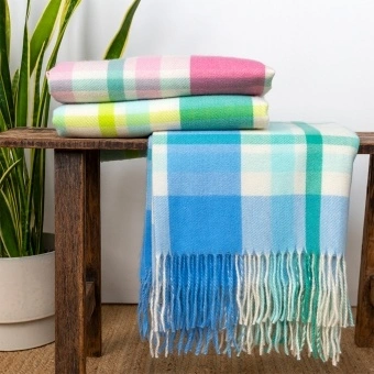 Checked throw blanket displayed on a wooden bench.