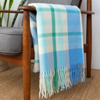 Blue, green and white check blanket displayed over a wooden armchair
