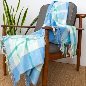 Blue, green and white check blanket displayed over a wooden chair