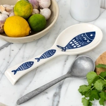 White ceramic spoon rest with blue fish design.