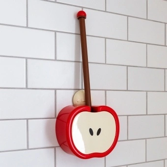 Red apple-shaped toilet brush and holder with wall mount, displayed against white tiled wall.