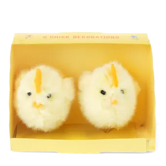 Two fluffy yellow chick decorations sitting side by side inside a small yellow cardboard box
