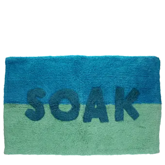 Blue and green bath mat with the word ‘SOAK’ in the center.