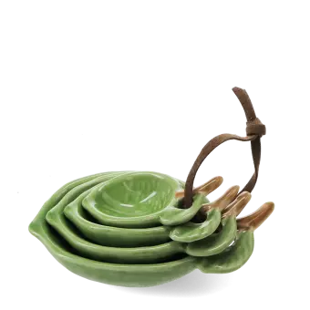 stackable ceramic measuring spoons shaped like green leaves with brown stem handles