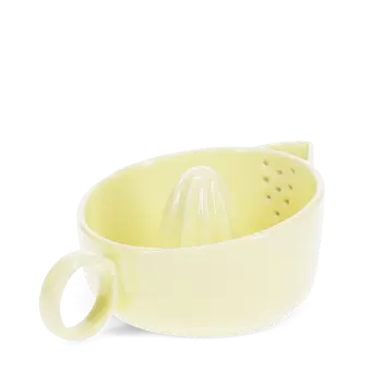 Yellow stoneware lemon squeezer with handle and pouring spout.