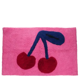 Pink bath mat with a cherry design in red and dark blue.