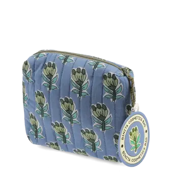 Blue quilted makeup bag with green and blue flowers and a tag.