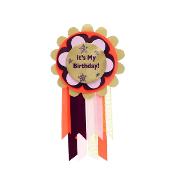 Colourful birthday badge with a gold centre reading ‘It’s My Birthday!’ and ribbons.