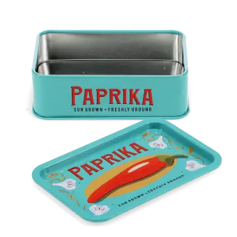 Open mini storage tin with the lid beside it, featuring an illustrated paprika on the lid.