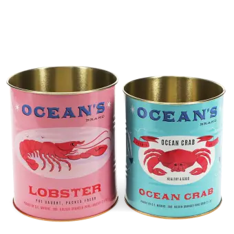 Two Ocean’s Brand storage tins featuring lobster and crab illustrations in pink and blue.