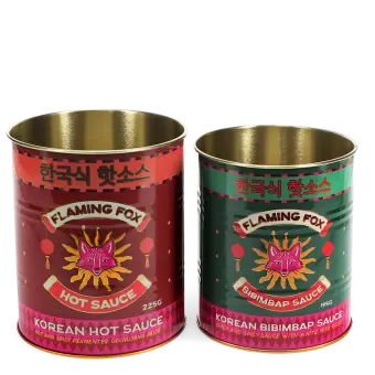 Two Flaming Fox Korean sauce storage tins, one red hot sauce and one green bibimbap design
