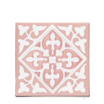 Pink ceramic coaster with white ornate tile pattern.