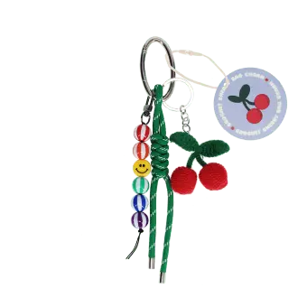 Crochet cherry bag charm with green cord strap, colourful beads and tag.