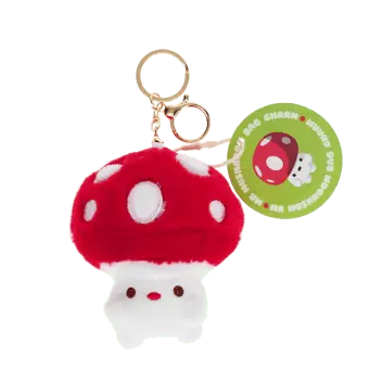 Plush mushroom bag charm with red spotted cap, gold keyring and soft white base with tag.