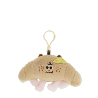 Fluffy croissant bag charm with smiley face, cheese patch and clip attachment