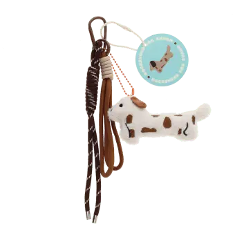 Plush sausage dog bag charm with brown spots, cord strap and metal clip with tag.