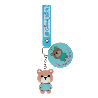 Bear bag charm with blue outfit, silicone wrist strap and silver keyring with tag.