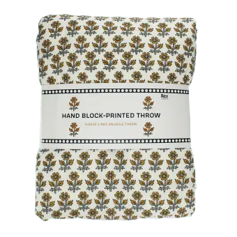 Hand block-printed throw with yellow floral pattern, folded in packaging.